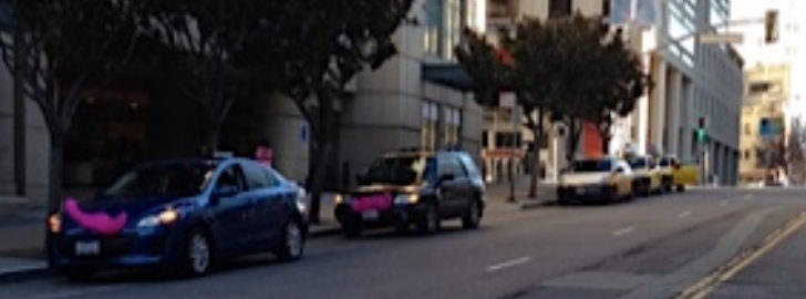 Two Lyft vehicles wait for fares at a San Francisco hotel